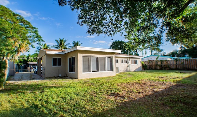 rear view of property featuring a yard