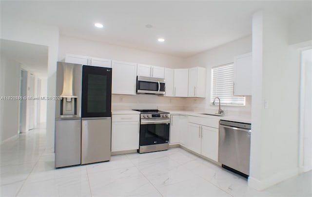 kitchen with sink, white cabinets, and appliances with stainless steel finishes