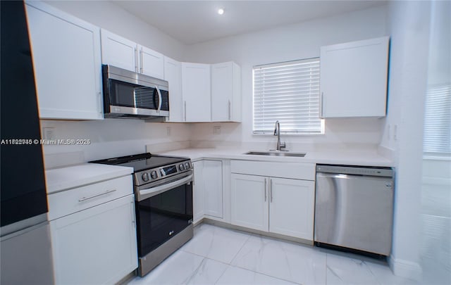 kitchen featuring white cabinetry, sink, and appliances with stainless steel finishes