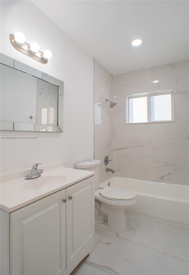 full bathroom featuring vanity, tiled shower / bath combo, and toilet