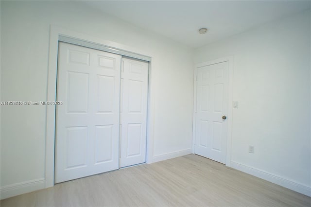 unfurnished bedroom featuring light hardwood / wood-style floors and a closet