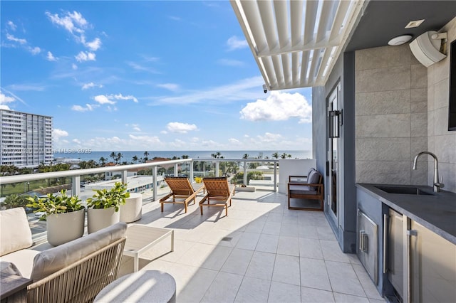 balcony featuring sink, a water view, and an outdoor hangout area