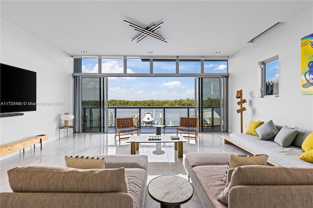 living area with baseboards, floor to ceiling windows, and a water view