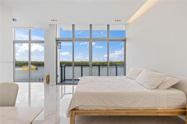 bedroom with access to outside, expansive windows, a water view, and multiple windows