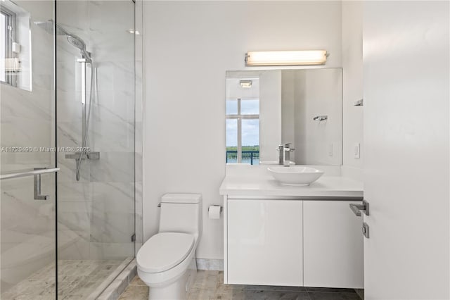 bathroom with vanity, toilet, and a marble finish shower