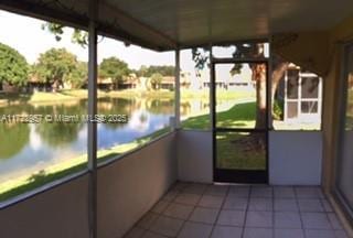 unfurnished sunroom featuring a water view