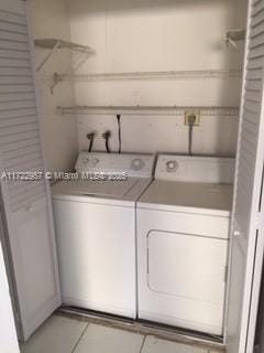 laundry room with washing machine and dryer and light tile patterned floors