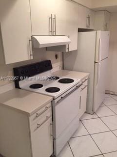 kitchen featuring white cabinets, white range with electric stovetop, and light tile patterned flooring