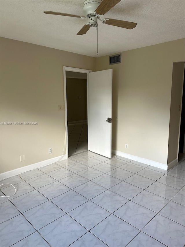 empty room featuring ceiling fan and a textured ceiling