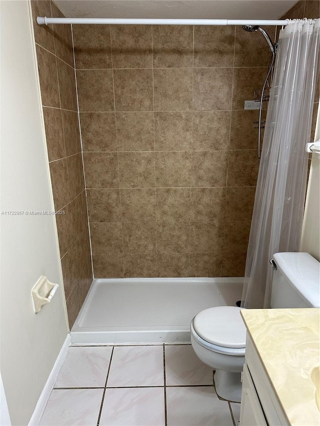 bathroom featuring toilet, tile patterned flooring, vanity, and walk in shower