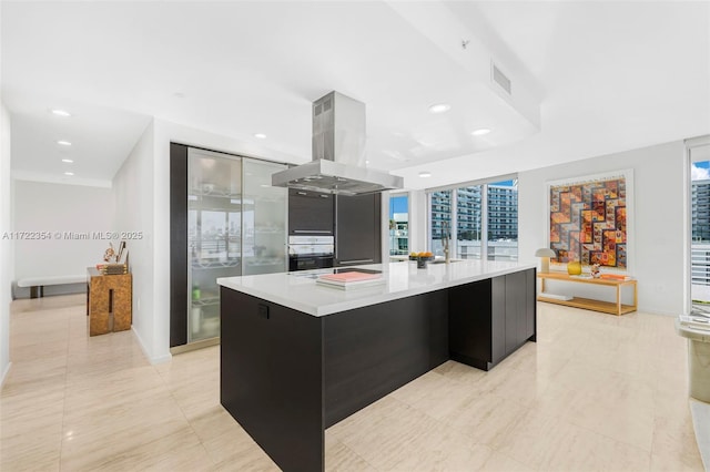 kitchen featuring black oven, island range hood, and a spacious island