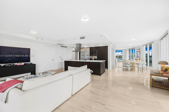 living room featuring floor to ceiling windows and sink