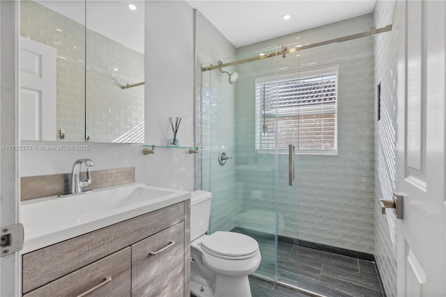 bathroom featuring walk in shower, vanity, and toilet