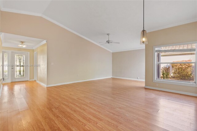 unfurnished living room featuring vaulted ceiling, ornamental molding, ceiling fan, and light wood-type flooring