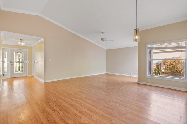 unfurnished room featuring lofted ceiling, light wood-style floors, baseboards, and crown molding