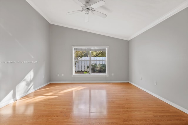 unfurnished room featuring light wood-style floors, baseboards, ornamental molding, and vaulted ceiling