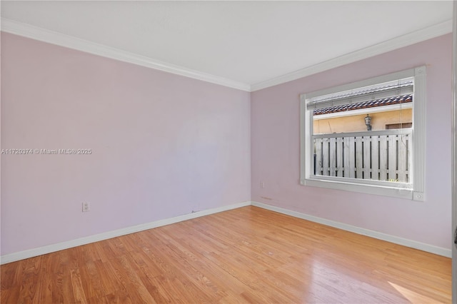 spare room featuring crown molding and light hardwood / wood-style floors