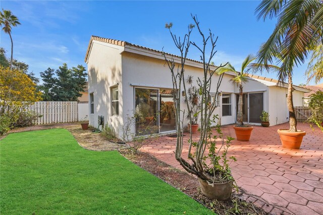 back of property featuring a yard and a patio area