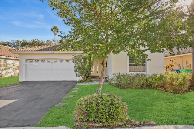 view of front of home with a garage, driveway, a front yard, and stucco siding