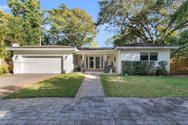 11433 NE 6th Ave, Biscayne Park, FL 33161 - ranch-style house with a front lawn, a garage, and french doors