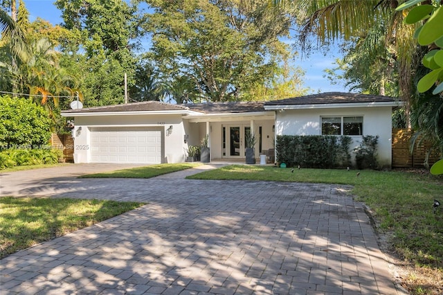 ranch-style home featuring a garage and a front yard