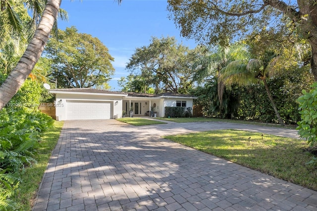 ranch-style home with a garage and a front lawn