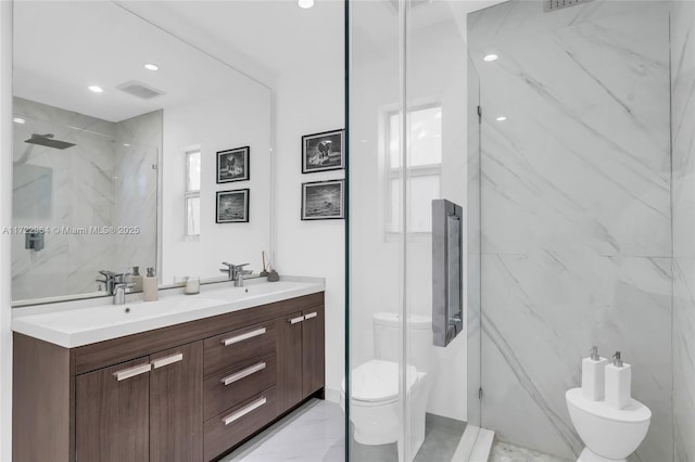 bathroom with an enclosed shower, vanity, and toilet