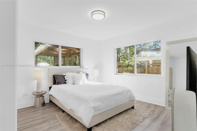 bedroom featuring light wood-type flooring and multiple windows