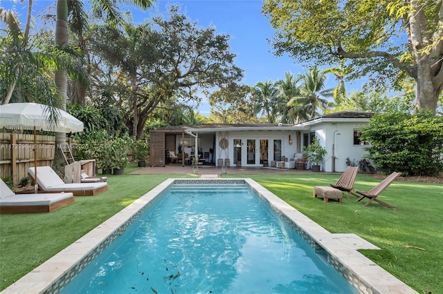 back of house with french doors and a lawn