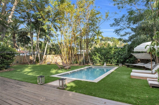 view of swimming pool with a yard and a deck