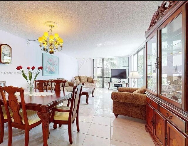 dining room with a textured ceiling, a wall of windows, a notable chandelier, and light tile patterned flooring