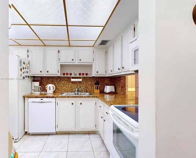 kitchen featuring white appliances, white cabinets, sink, decorative backsplash, and light tile patterned flooring