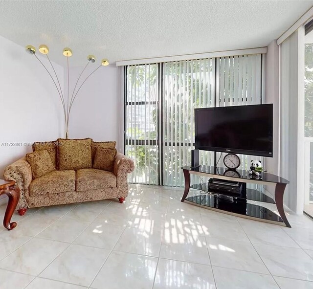 living room featuring tile patterned floors, expansive windows, and a textured ceiling