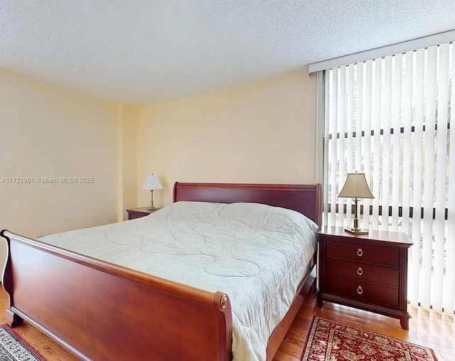 bedroom featuring a textured ceiling and wood finished floors