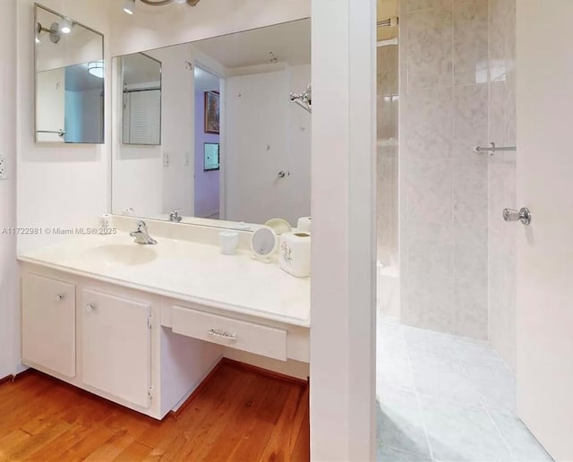 bathroom featuring vanity, wood-type flooring, and walk in shower