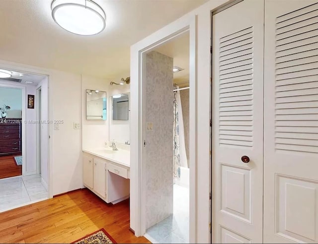 bathroom featuring wood-type flooring, vanity, and curtained shower