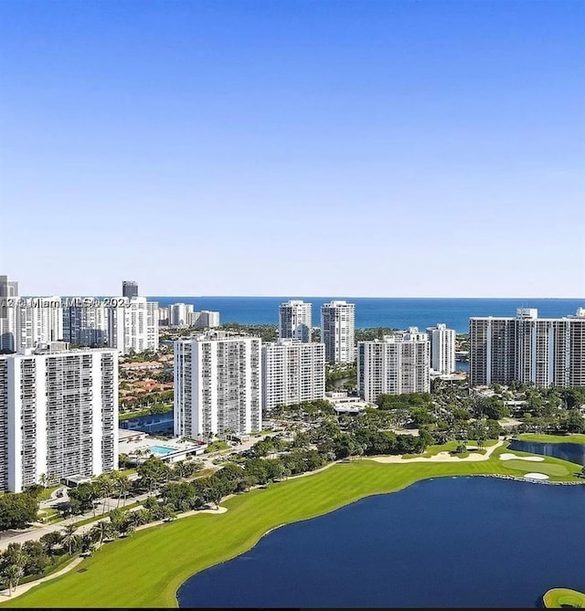 bird's eye view with view of golf course, a water view, and a city view