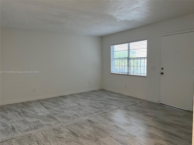 spare room with a textured ceiling