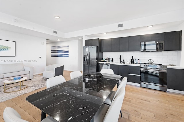 dining space featuring sink and light hardwood / wood-style floors