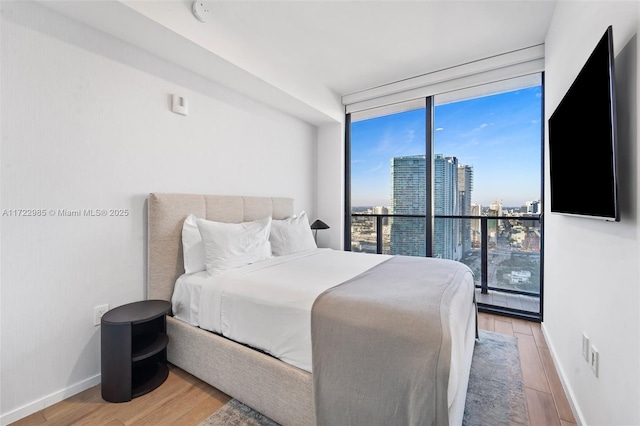 bedroom featuring floor to ceiling windows and hardwood / wood-style floors