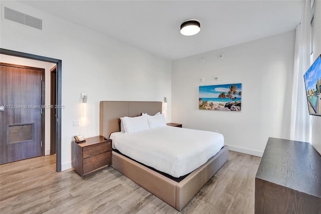 bedroom with baseboards, visible vents, and light wood-style floors