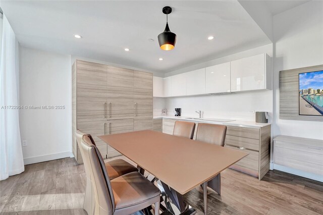 dining space with light wood-type flooring, baseboards, and recessed lighting