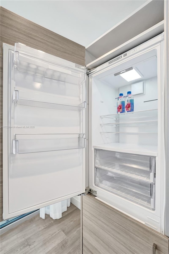 interior details with light wood finished floors and stainless steel built in refrigerator