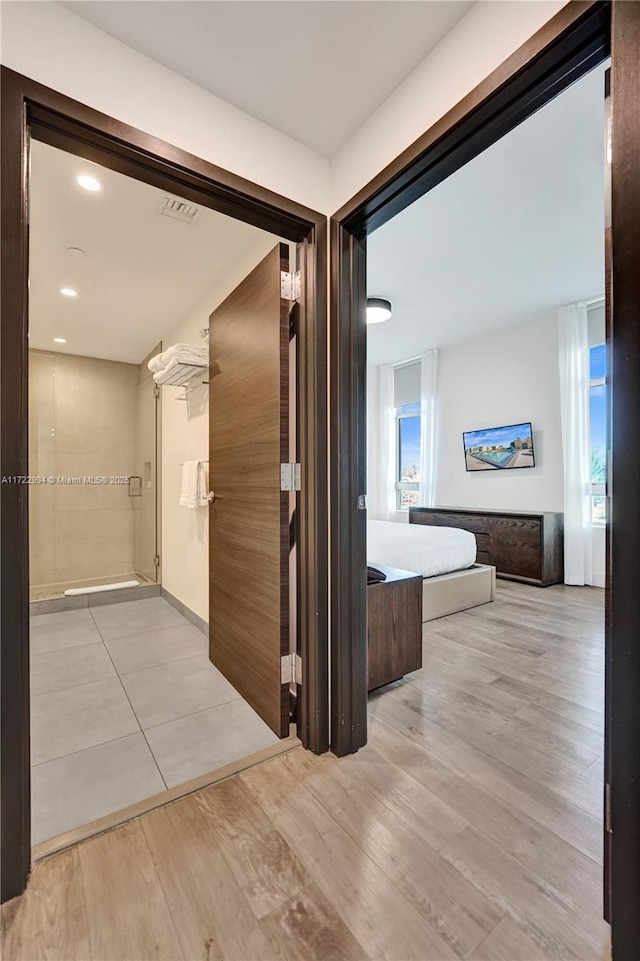 hall featuring recessed lighting, visible vents, and light wood-style floors