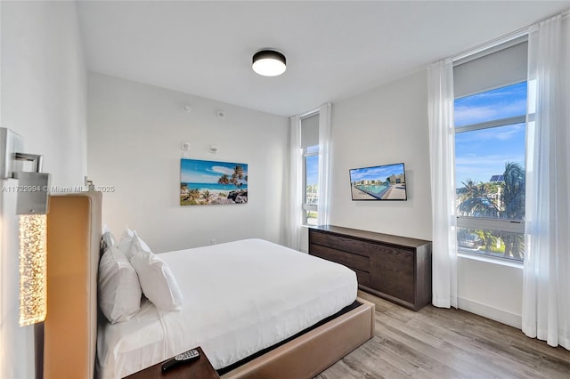 bedroom featuring light wood-style floors and baseboards