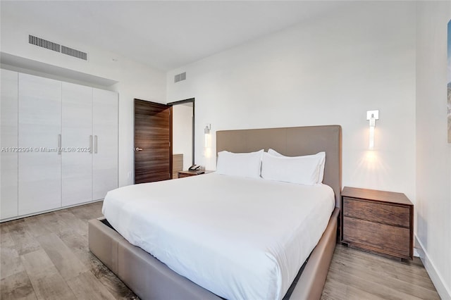 bedroom featuring visible vents and light wood-style floors