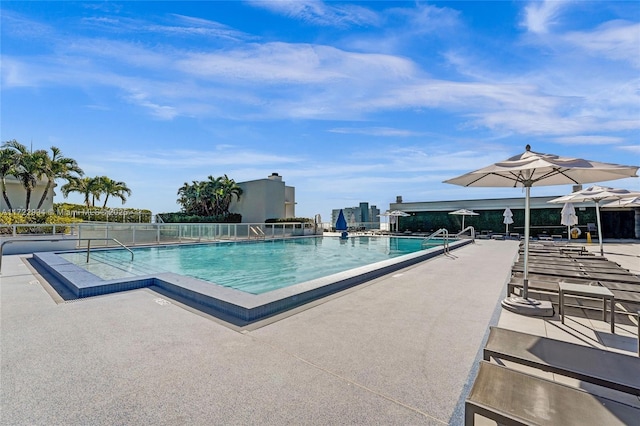 community pool featuring fence and a patio