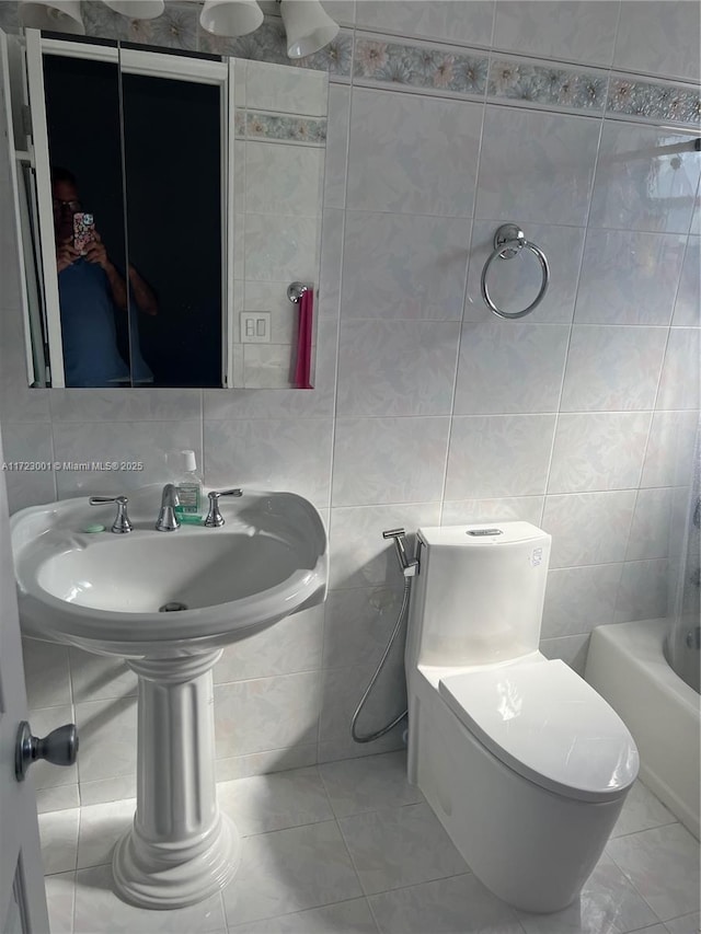 bathroom featuring tile patterned flooring, toilet, tile walls, and sink