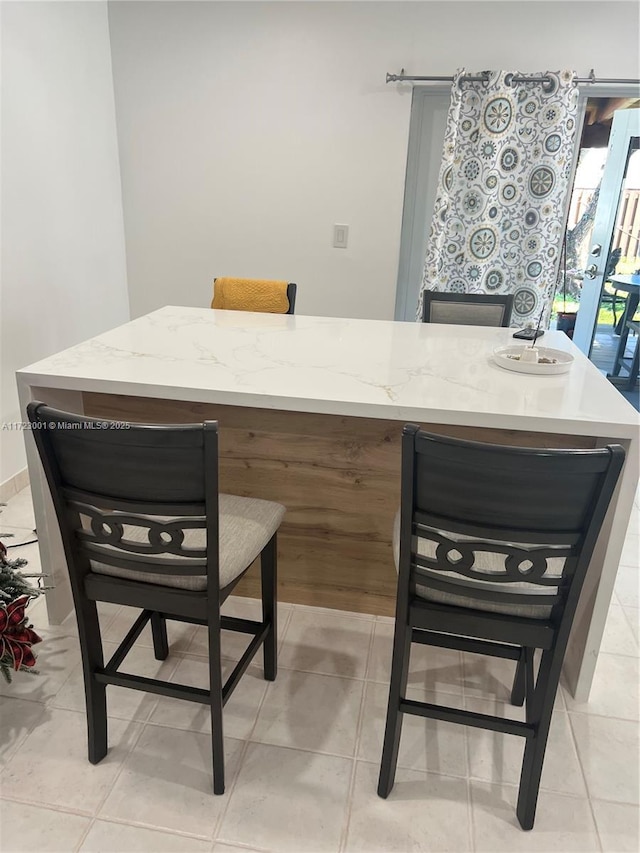 bar featuring light tile patterned floors and light stone counters