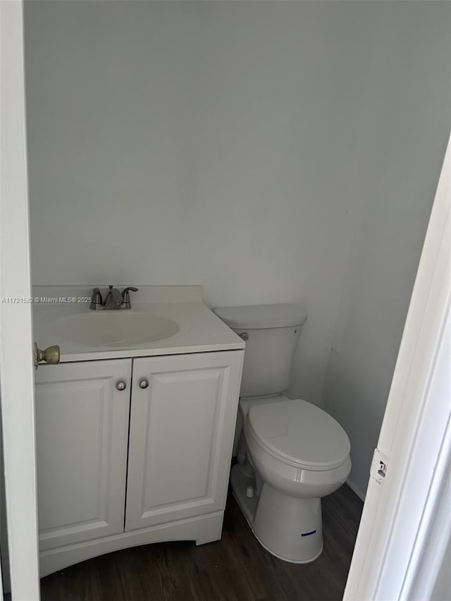 bathroom featuring wood-type flooring, vanity, and toilet